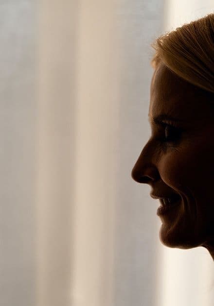 Silhouetted profile of a smiling woman with blonde hair.